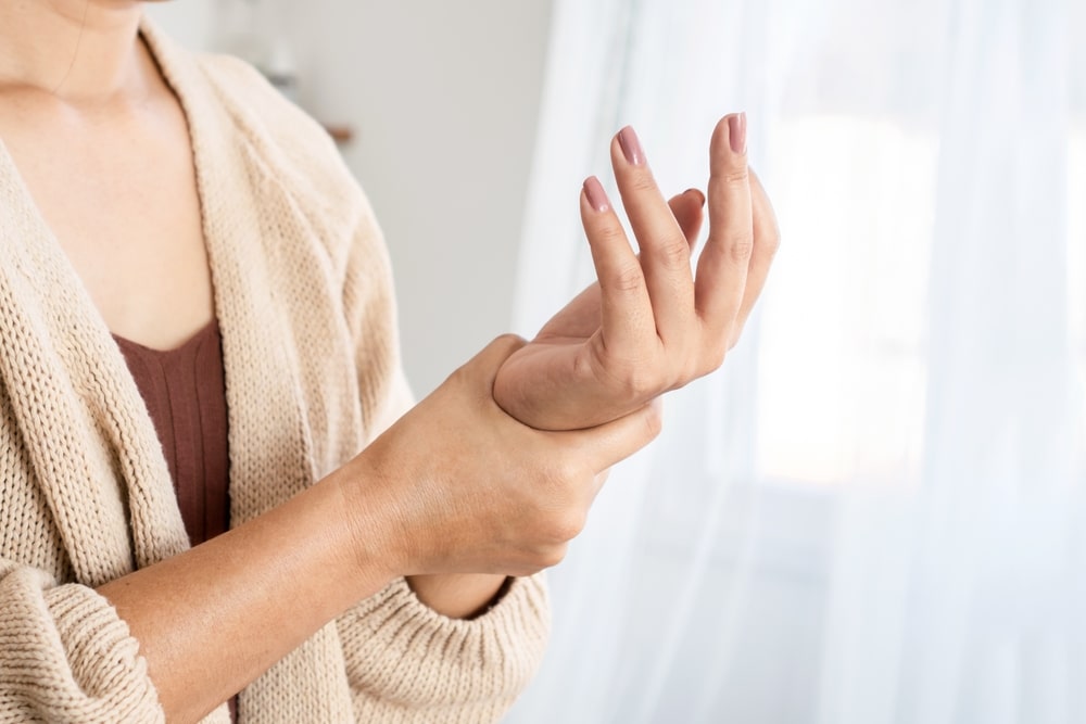 Woman holding wrist in pain from carpal tunnel syndrome.