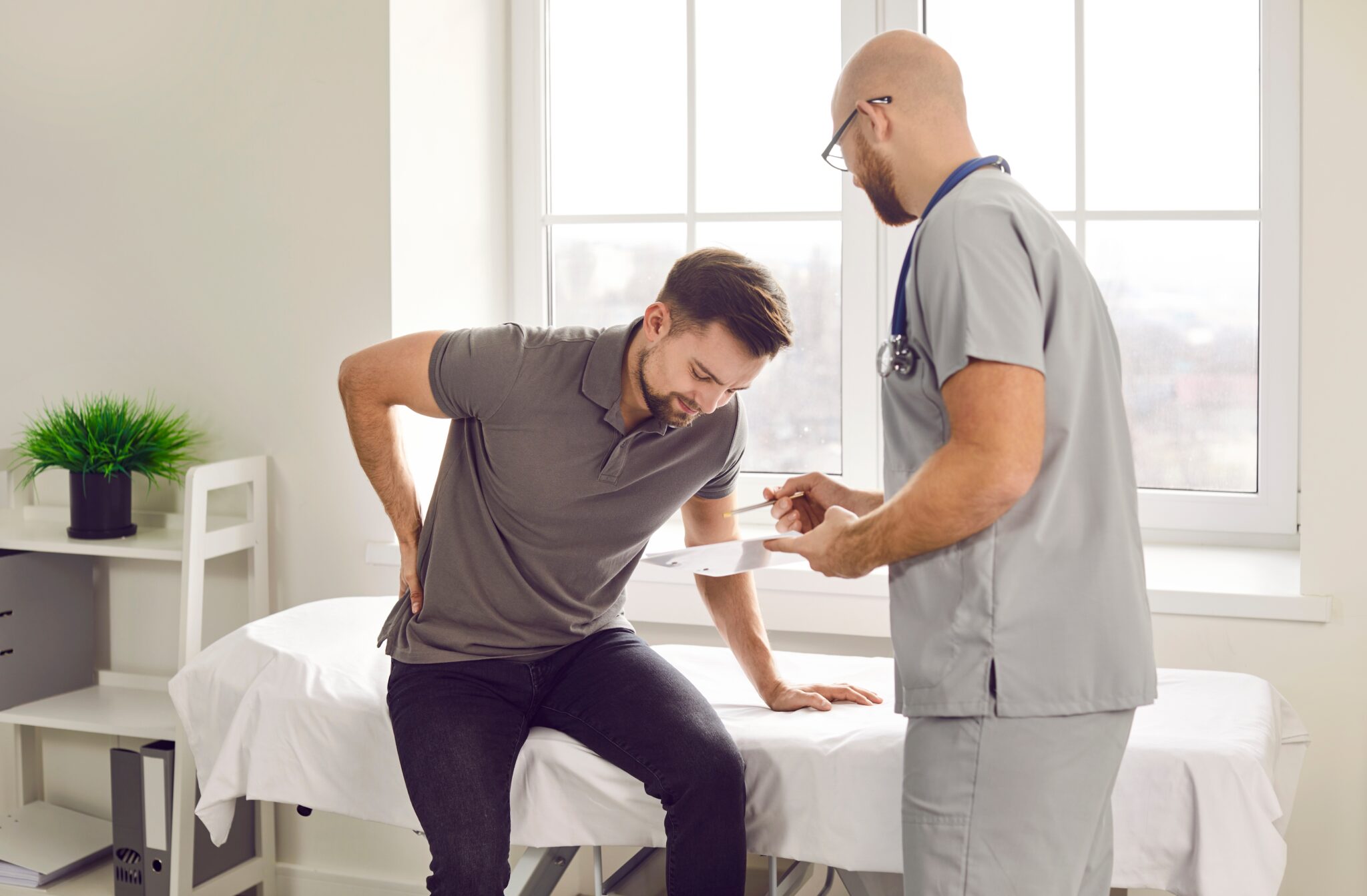 Orthopaedic specialist with patient discussing low back pain symptoms