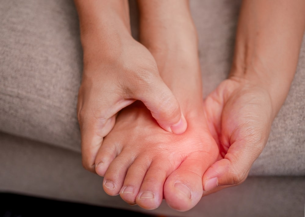 Person holding foot and showing painful bunion