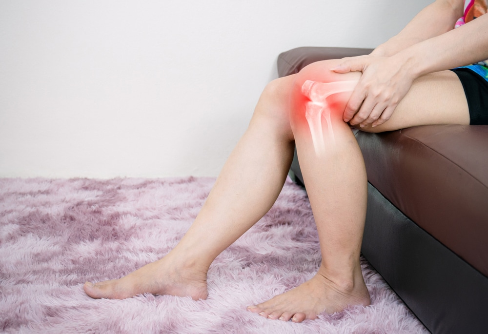 A person with knee osteoarthritis holding their leg